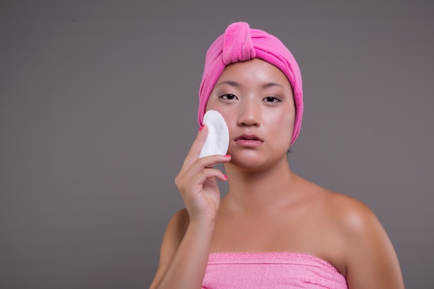 Pretty chinese woman taking care of her skin isolated from the background beauty concept