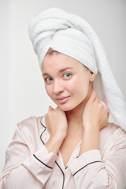 Pretty clean girl in silk pajamas going to take care of her face and body after morning shower and washing hair