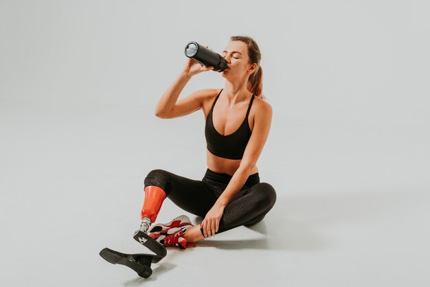 Pretty and confident woman with leg disability drinking water