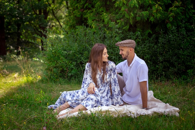 Una bella coppia innamorata al picnic si sorride alla natura verde