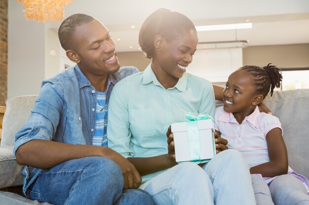 Pretty couple offer a present for their daughter