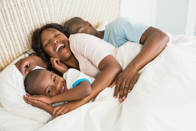 Pretty couple with his son in bed together at home