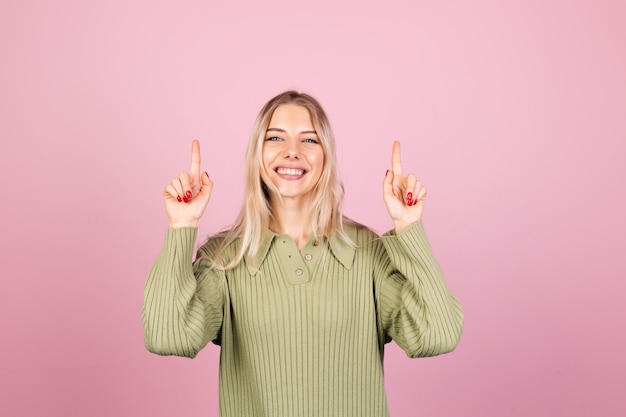 Pretty european woman in casual knitted sweater on pink wall