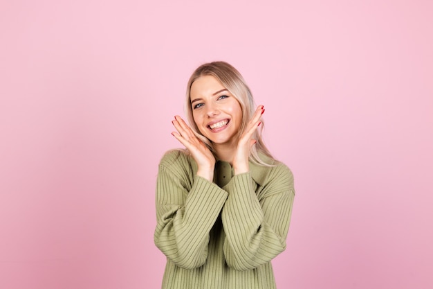 Donna abbastanza europea in maglione casual sulla parete rosa