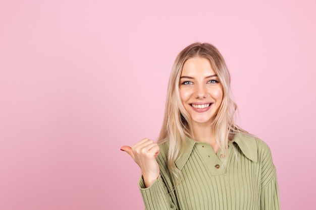 pretty european woman in casual sweater on pink wall