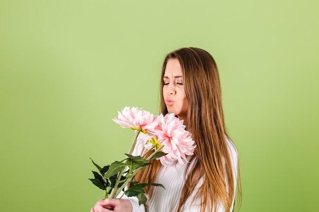 笑顔でピンクの花の花束を保持しているカジュアルな白いセーター孤立した、ロマンチックな外観のかなりヨーロッパの女性