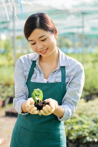 Pretty farm worker holding plant