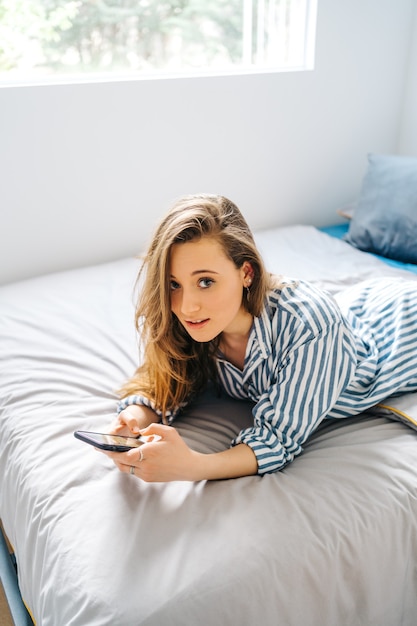 Фото Симпатичная женщина создает контент для социальных сетей influencer в спальне расслабляется за видеочатом