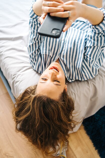 pretty female creating content for social media Influencer in bedroom relaxed having video chat