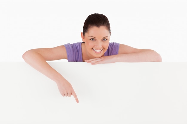 Pretty female pointing at a billboard