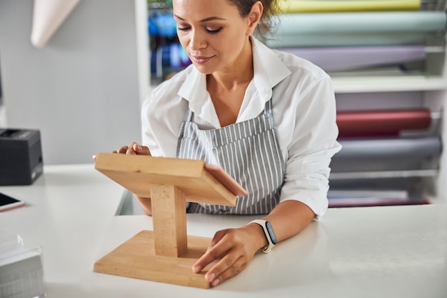 Pretty female shop assistant clicking on the tablet screen