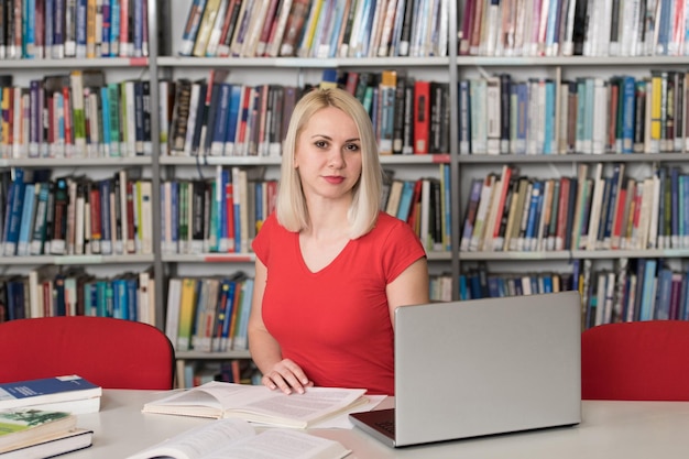 Pretty Female Student With Books Working in a High School Library