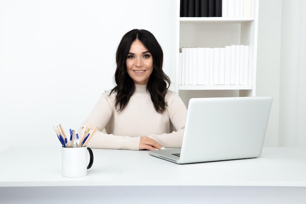 Pretty female worker in office isolated sitting at the desk with computer