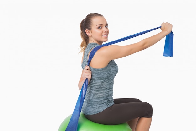 Photo pretty fit woman stretching her arms with a resistance band