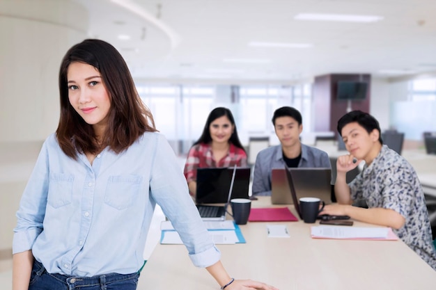 Pretty freelancer standing in front of her team