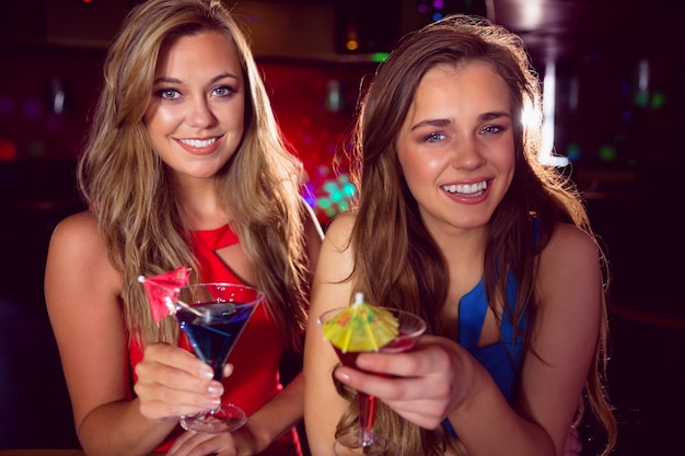 Pretty friends drinking cocktails together