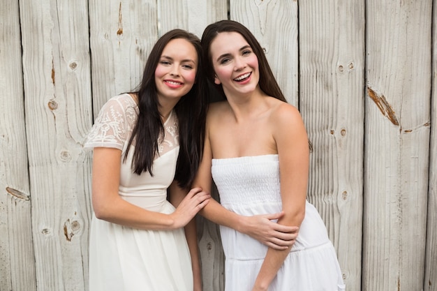 Pretty friends smiling in white dresses