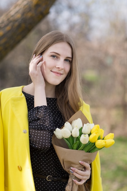 Pretty girl in coat with flowers