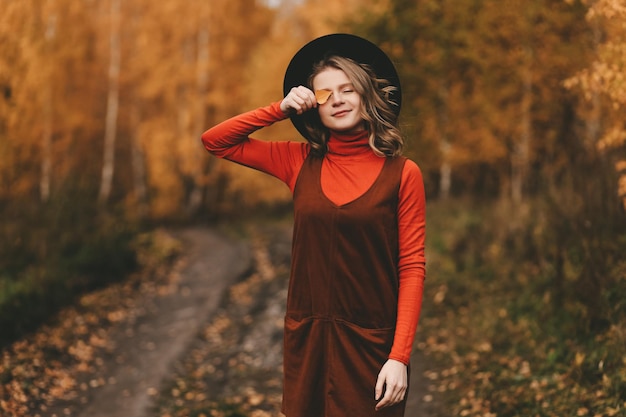 Foto una bella ragazza si diverte in solitudine beve caffè cammina nella foresta d'autunno nella natura in autunno