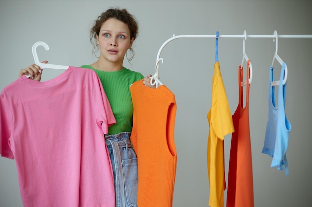 Pretty girl green tshirts near clothes hangers isolated backgrounds unaltered