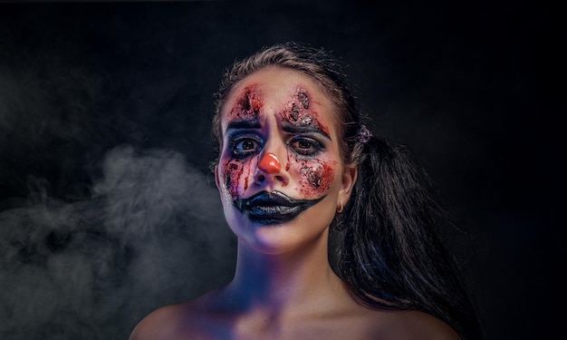 Pretty girl has very creepy makeup for halloween in a role of\
creepy clown.