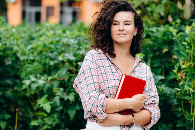 Pretty girl holding a book in her hands, looking away