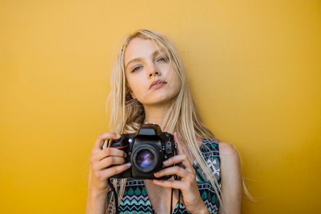 Photo pretty girl holding a camera