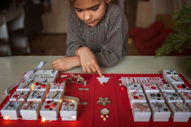 Pretty girl holds original advent calendar made of jewelry boxes and binder christmas diy craft