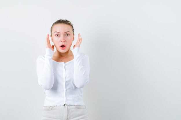 Pretty girl is showing she doesnt hear any sound on white background