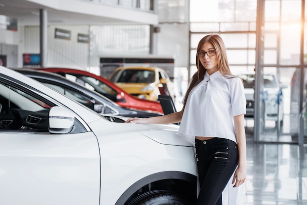 かわいい女の子が彼女の車の近くに立っています。