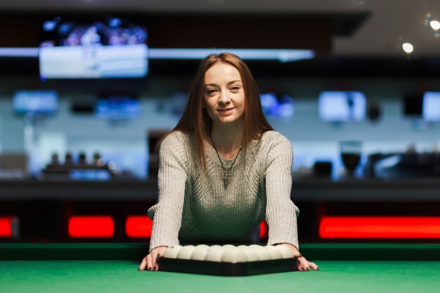 Pretty girl leaned on a pool table