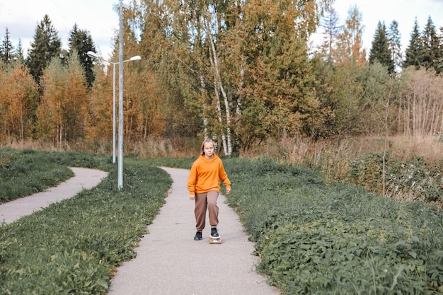 Foto bella ragazza che impara a fare skateboard all'aperto in una bella giornata autunnale