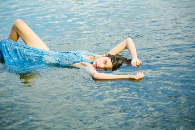 Photo pretty girl lies in water