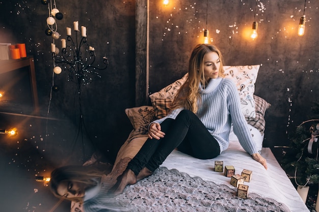 Pretty girl sitting on the bed, portrait