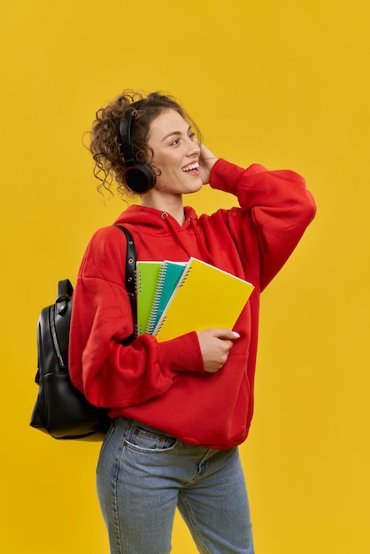 Bella ragazza in piedi sorridente ascoltando musica