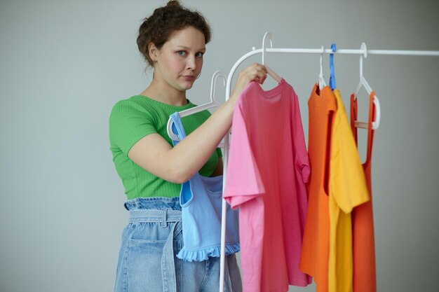 pretty girl trying on clothes wardrobe youth style light background unaltered
