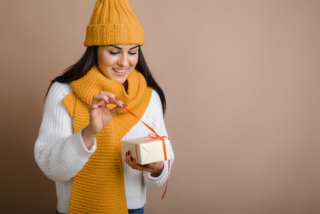 La ragazza graziosa libera il nastro rosso come regalo