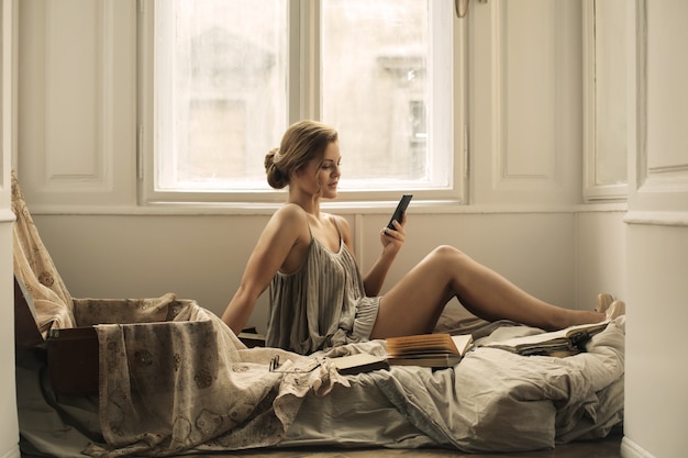 Pretty girl using her smartphone in bed