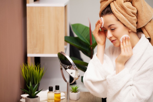 Photo pretty girl wipes the face after taking a shower sponge