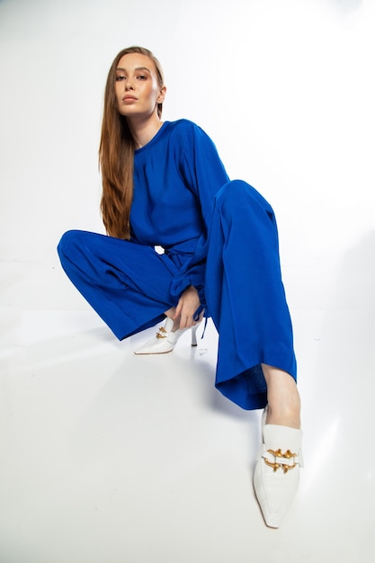 Pretty girl with ginger hair High fashion look beautiful young woman posing on white wall.