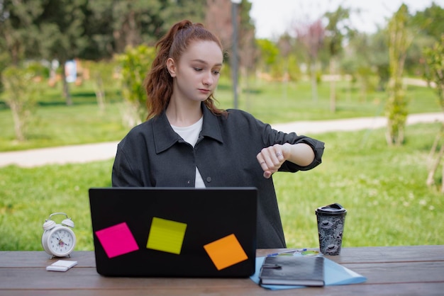 Pretty girl with red hair working in park looking down