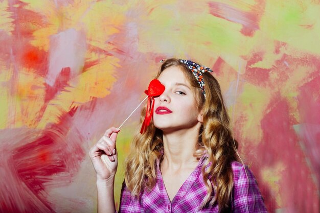 Pretty girl with red heart on stick for valentines day