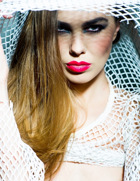 Pretty girl with red lips wearing beige fishnet shirt