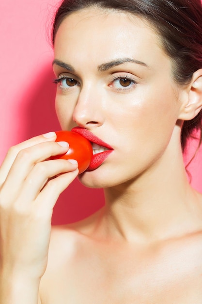Foto bella ragazza con pomodoro rosso