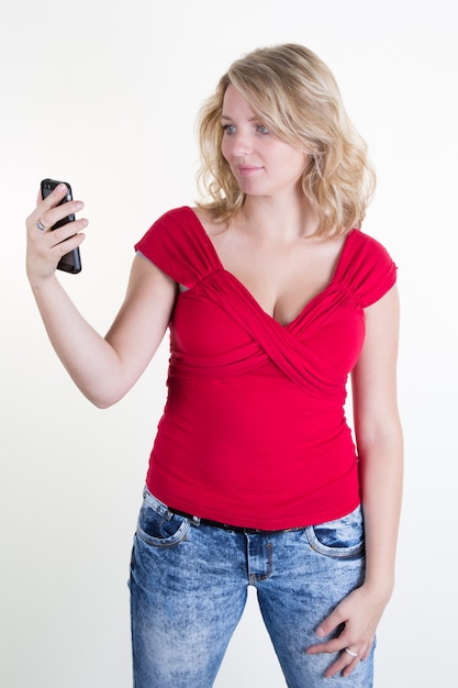 Pretty girl with a red top looking at her mobile phone