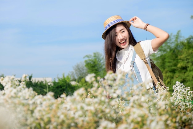 Pretty hipster asian teen girl in a spring white flower garden, vintage one and relax concept