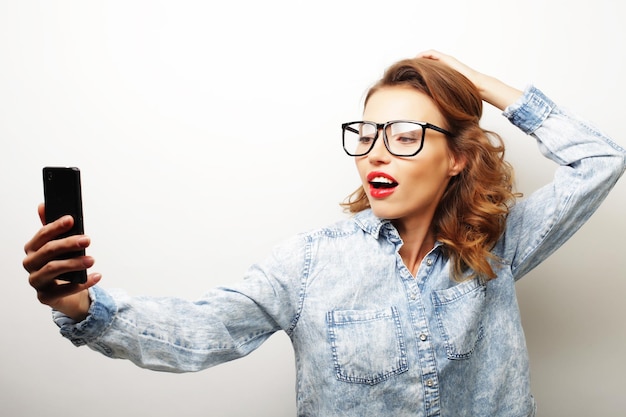 Pretty hipster girl taking selfie