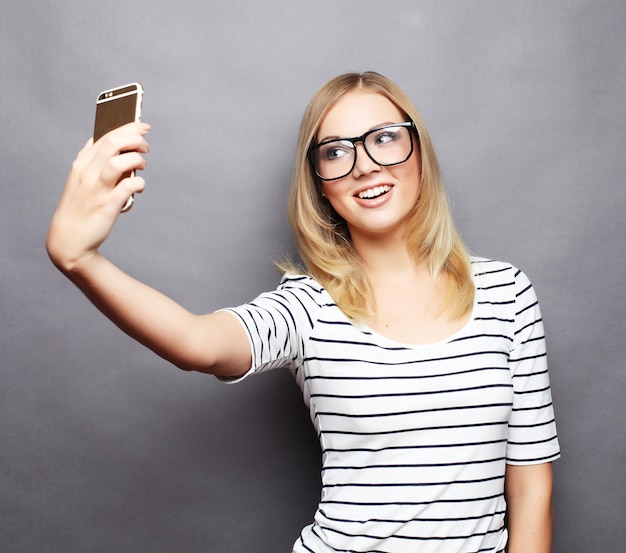 Pretty hipster girl taking selfie.