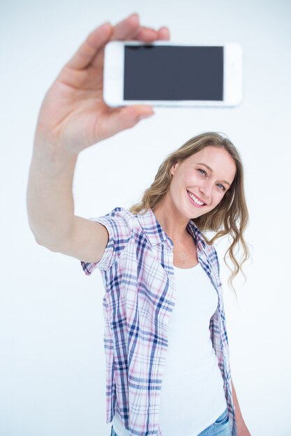 Foto bei pantaloni a vita bassa che prendono selfie con lo smartphone