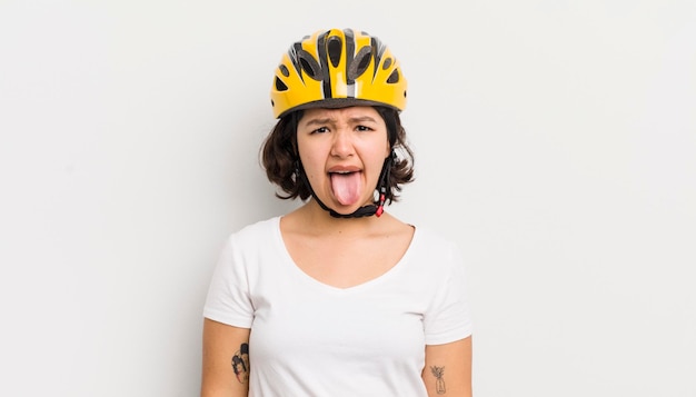 Pretty hispanic girl feeling disgusted and irritated and tongue out bike concept